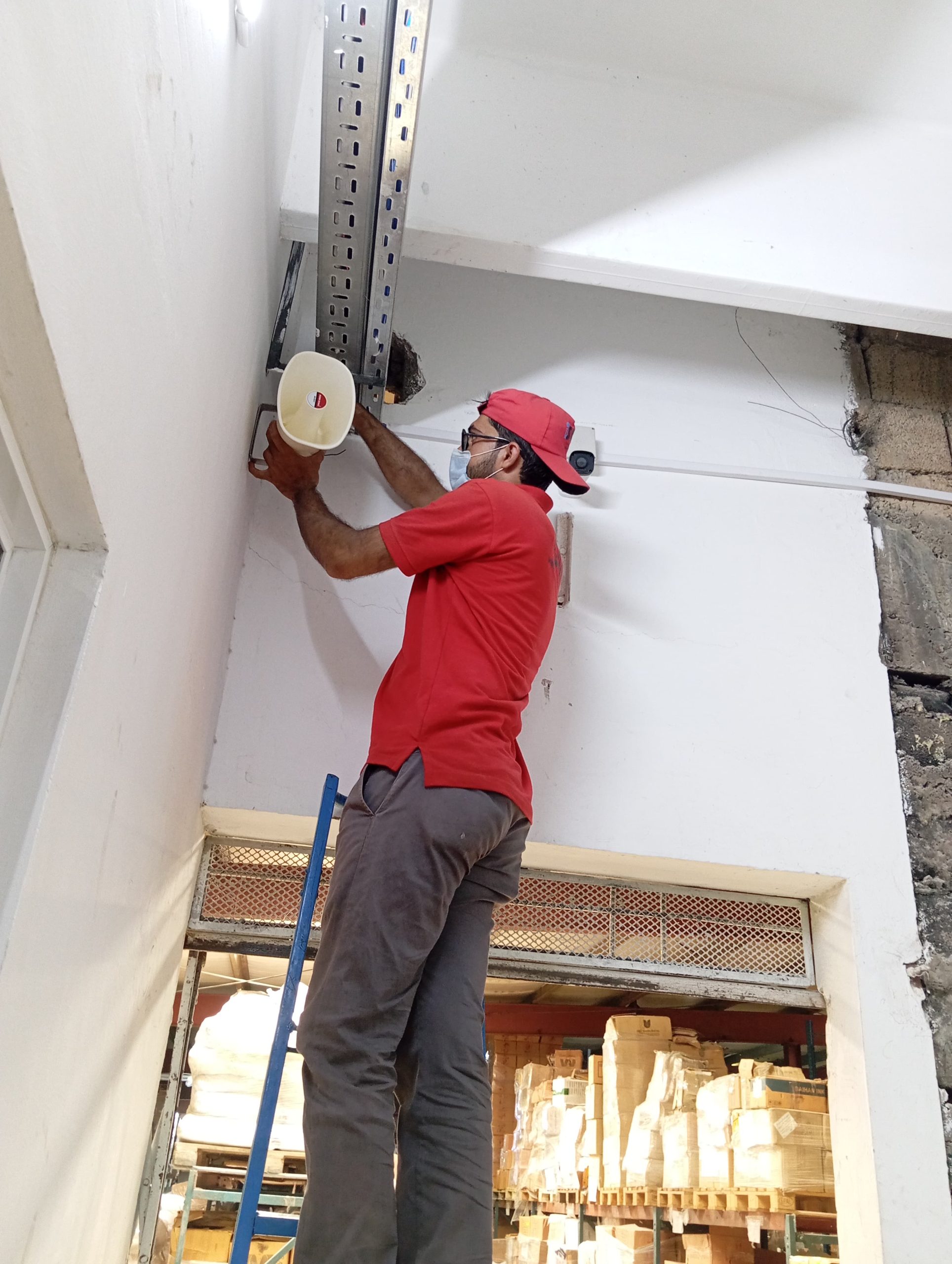 Israintech technician mounting a CCTV camera in a warehouse in Lahore